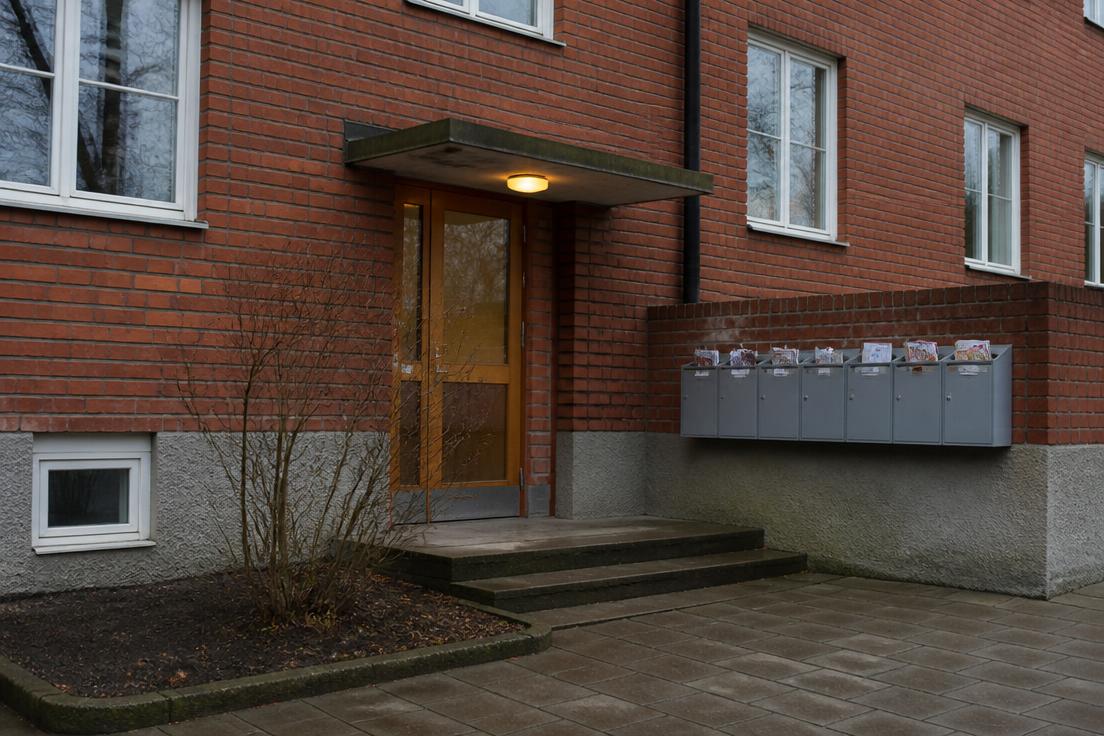 Person fyller i adressändring och flyttanmälan vid flyttlådor i en lägenhet i Nacka